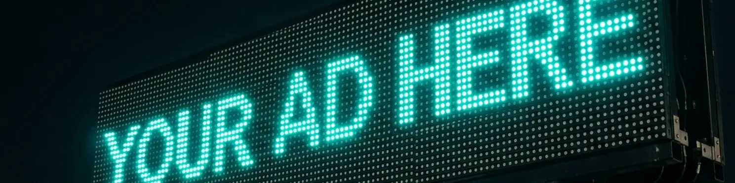 Closeup of the Aurora LED matrix displaying 'YOUR AD HERE' in glowing teal dot-matrix letters