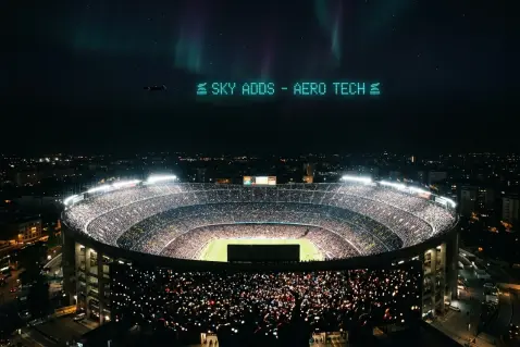 A packed stadium at night, glowing under floodlights